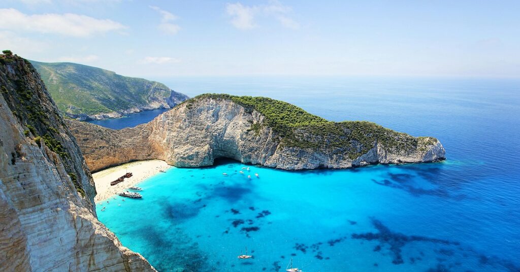 Illustration of a European beach during summer with golden sand, turquoise water, colorful umbrellas, and people enjoying activities, overlaid with the text 'Explore the Best Beaches in Europe This Summer'